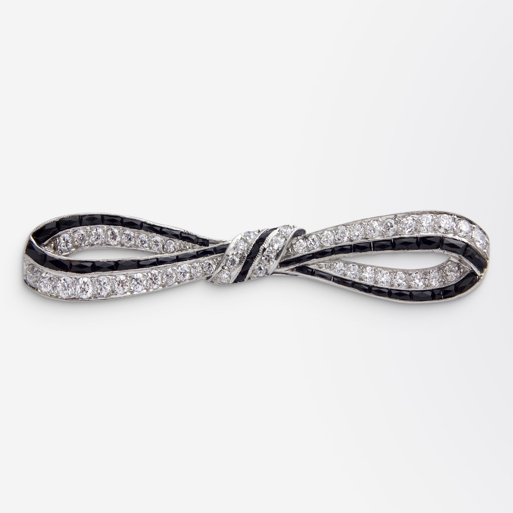 Broche nœud Art Déco en platine, onyx et diamants